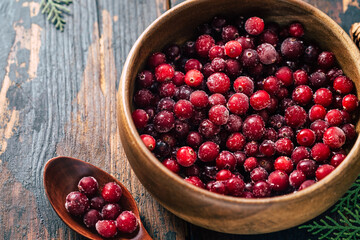 Cranberries in a plate on a wooden background. Copy space