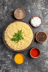 top view mashed potatoes in wooden bowl bowls with sea salt black pepper red pepper turmeric on dark background