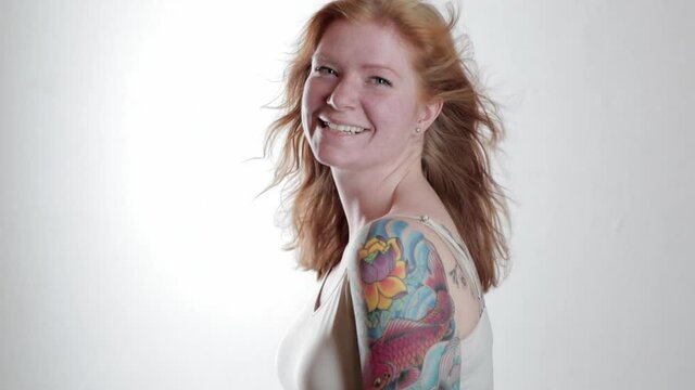 Wind blowing hair of Caucasian woman with tattoos