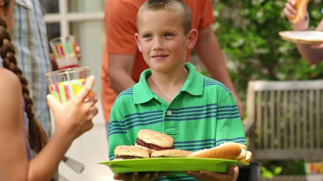 Close up of Caucasian boy scaring girl by pretending to drop plate of food