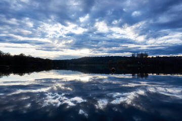 Fototapeta premium Clouds over the lake with marmor effect through the sunshine and reflections in the lake at the evening