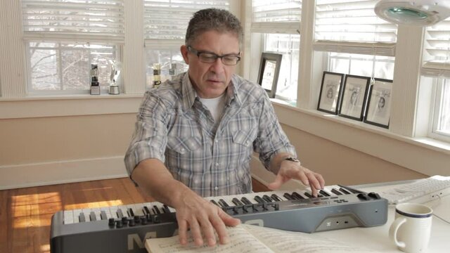 Mixed race man playing keyboard