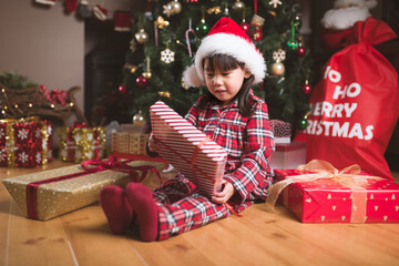 Obraz na płótnie Canvas young girl sit on floor and open Christmas gift box at home
