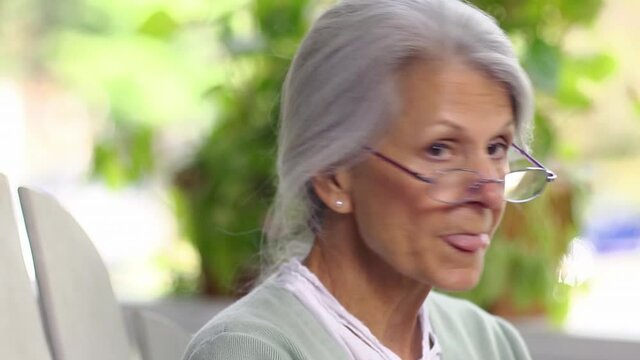Close up of distracted senior woman smiling then looking away