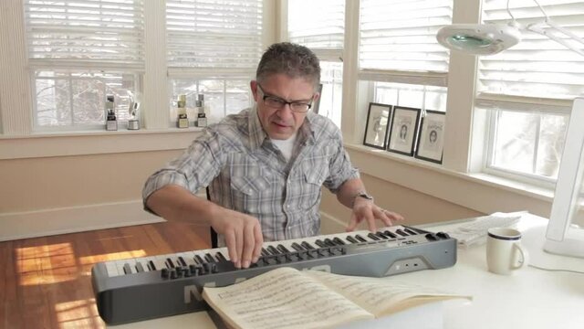 Mixed race man playing keyboard