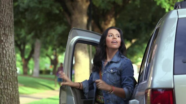 Hispanic woman parking and exiting car