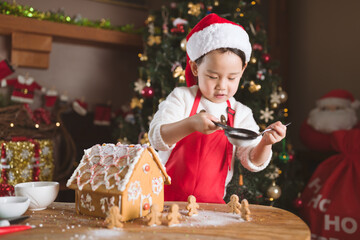 young girl making gingerbread house at home