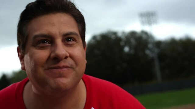 Hispanic man on baseball field taunting opponent