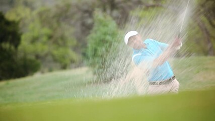 Black golfer celebrating hitting golf ball out of sand trap