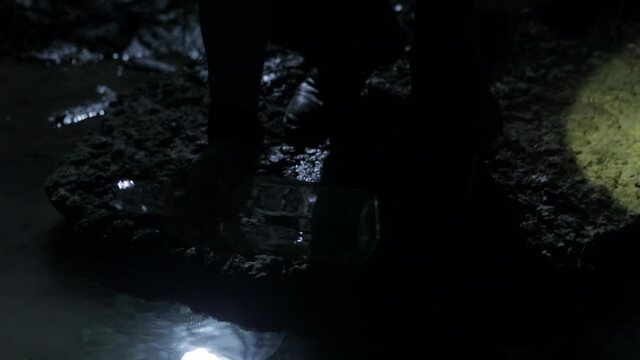 Close up of legs of man lurking near pond at night