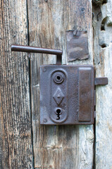 Old rustic wooden entrance door with antique door handle