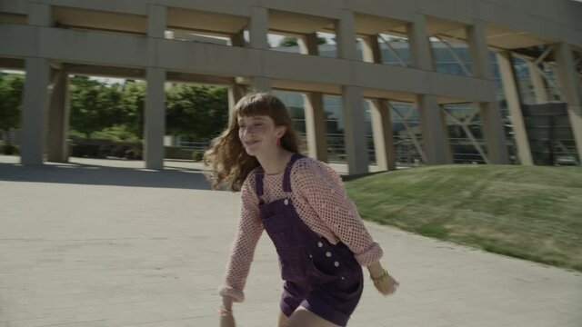 Slow motion tracking shot of girl looking at camera while roller skating / Salt Lake City, Utah, United States