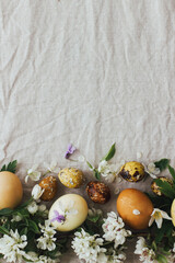 Obraz na płótnie Canvas Easter eggs with spring flowers on rustic linen, flat lay with space for text. Aesthetic card