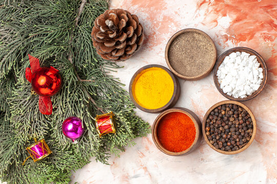 top view different seasonings with christmas tree and toys on a light background photo color pepper salt food