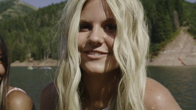 Slow motion panning close up of smiling teenagers at lake / Tibble Fork, Utah, United States