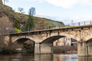 Stone bridge with people walking in a sunset.