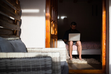 Fototapeta na wymiar man working on laptop in wooden cottage