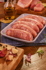 Brazilian pork leg sausage on white plate with spices and ingredients - Linguiça de pernil