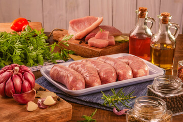 Brazilian pork leg sausage on white plate with spices and ingredients - Linguiça de pernil