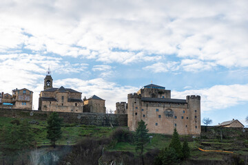 Obraz premium Horizontal view of the castle, church and some houses of Puebla de Sanabria in winter with Christmas decoration on a winter evening