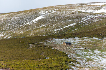 Horizontal view of a mountain refuge and people enjoying nature surrounded by ice and snow