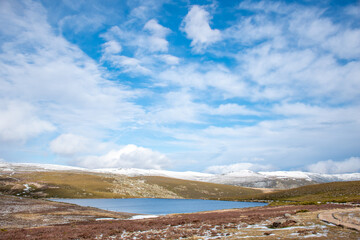 Horizontal view of a mountain lake in winter. Sunny day landscape and snowy mountains breathing pure and unpolluted air