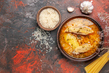 top view bowl of chicken soup bowl of rice dry spaghetti on dark red background with copy space
