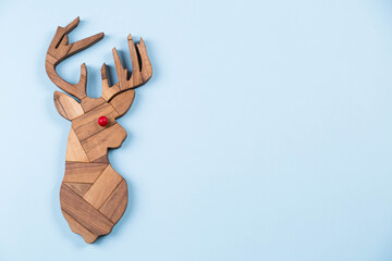 Wooden reindeer on blue background. minimalism, Christmas greeting card