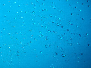 Fototapeta na wymiar Random water drops on the blue PVC surface