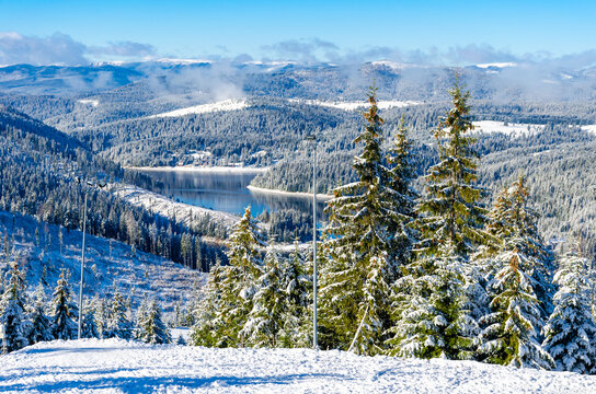 Beautiful panoramic view over the "Marisel" ski slope in winter season and Belis lake in the valley, Cluj county Romania.