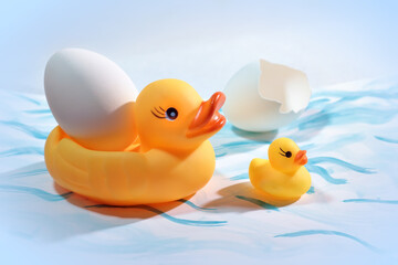 Toy duck ducklings and duck egg on painted paper close-up. Easter composition.