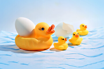 Toy duck  ducklings and duck egg on painted paper close-up. Easter composition.