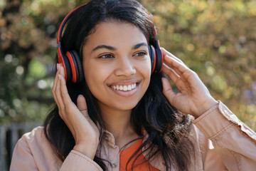 Portrait of beautiful African American woman listening to music on headphones, smiling
