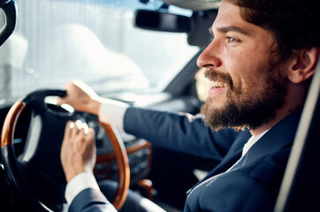 Fototapeta na wymiar bearded man in suit driving a car luxury trip lifestyle