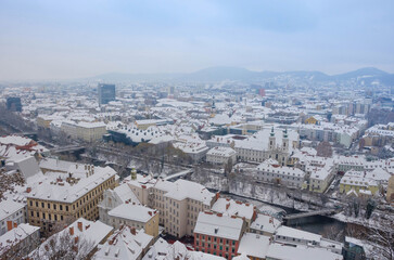 Cityscape of Graz with Mariahilfer church and historic and modern buildings of Graz, Styria region, Austria, with snow, in winter