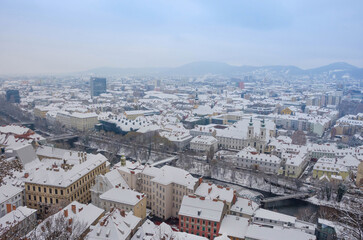 Obraz premium Cityscape of Graz with Mariahilfer church and historic and modern buildings of Graz, Styria region, Austria, with snow, in winter