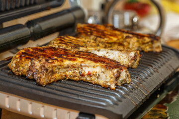 grilling steaks on a flaming grill