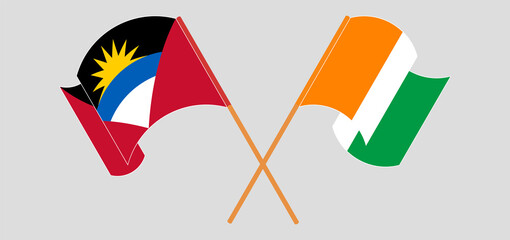 Crossed and waving flags of Antigua and Barbuda and Republic of Ivory Coast