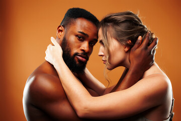 Obraz premium Young pretty couple diverse races together posing sensitive on brown background, lifestyle people concept