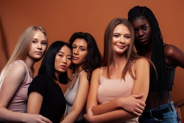 Fototapeta premium young pretty asian, caucasian, afro woman posing cheerful together on brown background, lifestyle diverse nationality people concept