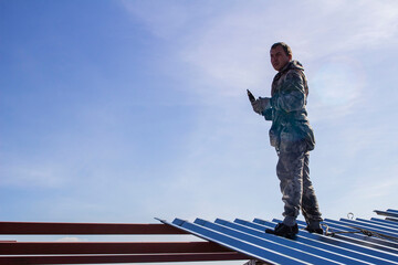 an industrial climber worker, insured on a safety rope, performing a task of installing metal structures at a high altitude