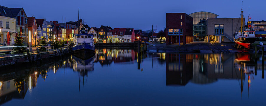 North Sea port city of Husum at Christmas time by sunset. "The gray town by the sea." View on Christmas port of Husum with Christmas trees and beautiful sunset.