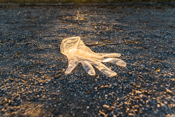 Plastic gloves from a supermarket abandoned on the ground in a park, polluting.