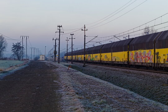 Graffiti painted freight trains running along a dirt road