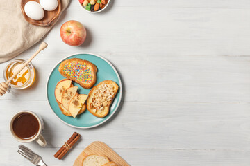 Breakfast with French toast, fruit, honey and a Cup of cocoa.Top view on light wood background with space