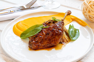 Duck leg confit on white plate