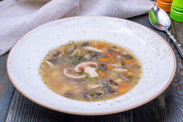 soup mushroom in a plate on blue wooden table
