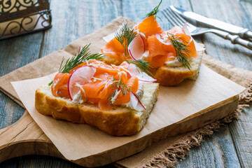 Bruschetta with salmon and cheese on beautiful blue wooden table