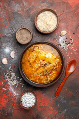 top view chicken soup bowls with pepper rice sea salt garlic spoon on dark red background