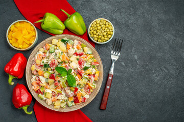 top close view of veggie salad on red napkin with veggies and fork on side with free place for your text on right side on dark grey background